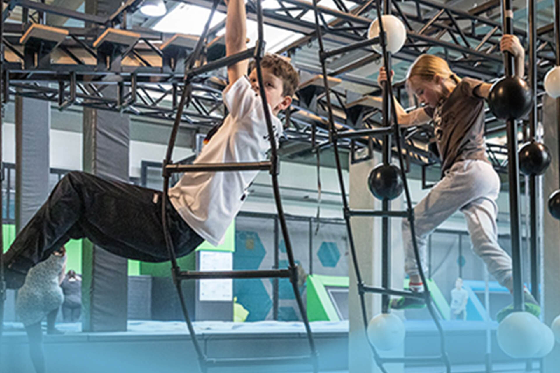Kinder meistern Kletter- und Ninja-Hindernisse bei Jump for Challenge im SkyandSand Trampolinpark Würzburg.