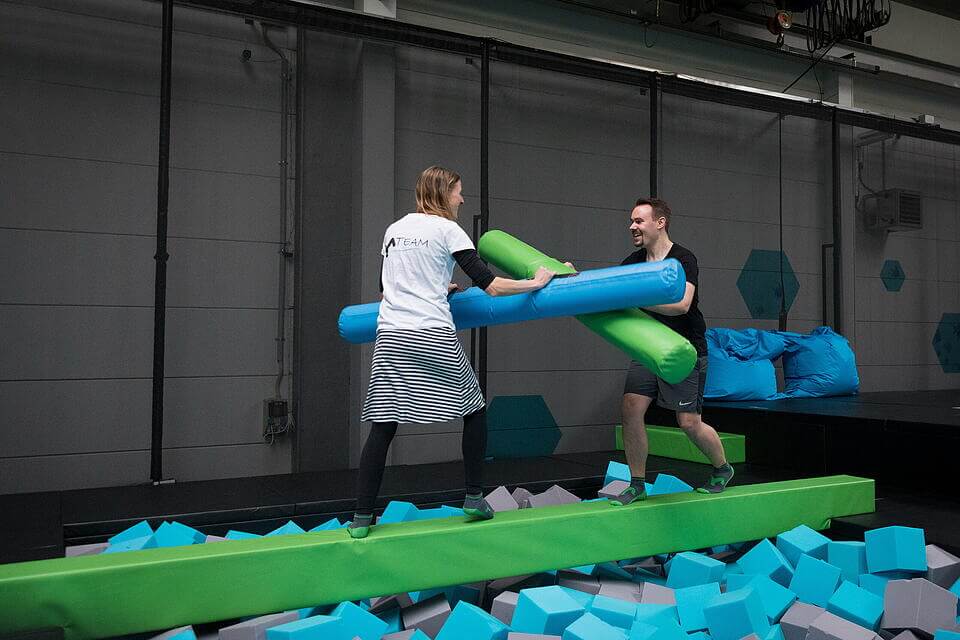 Teilnehmer eines Sprungcamps hören gemeinsam den Anweisungen der Trainer im SkyandSand Trampolinpark Würzburg zu.