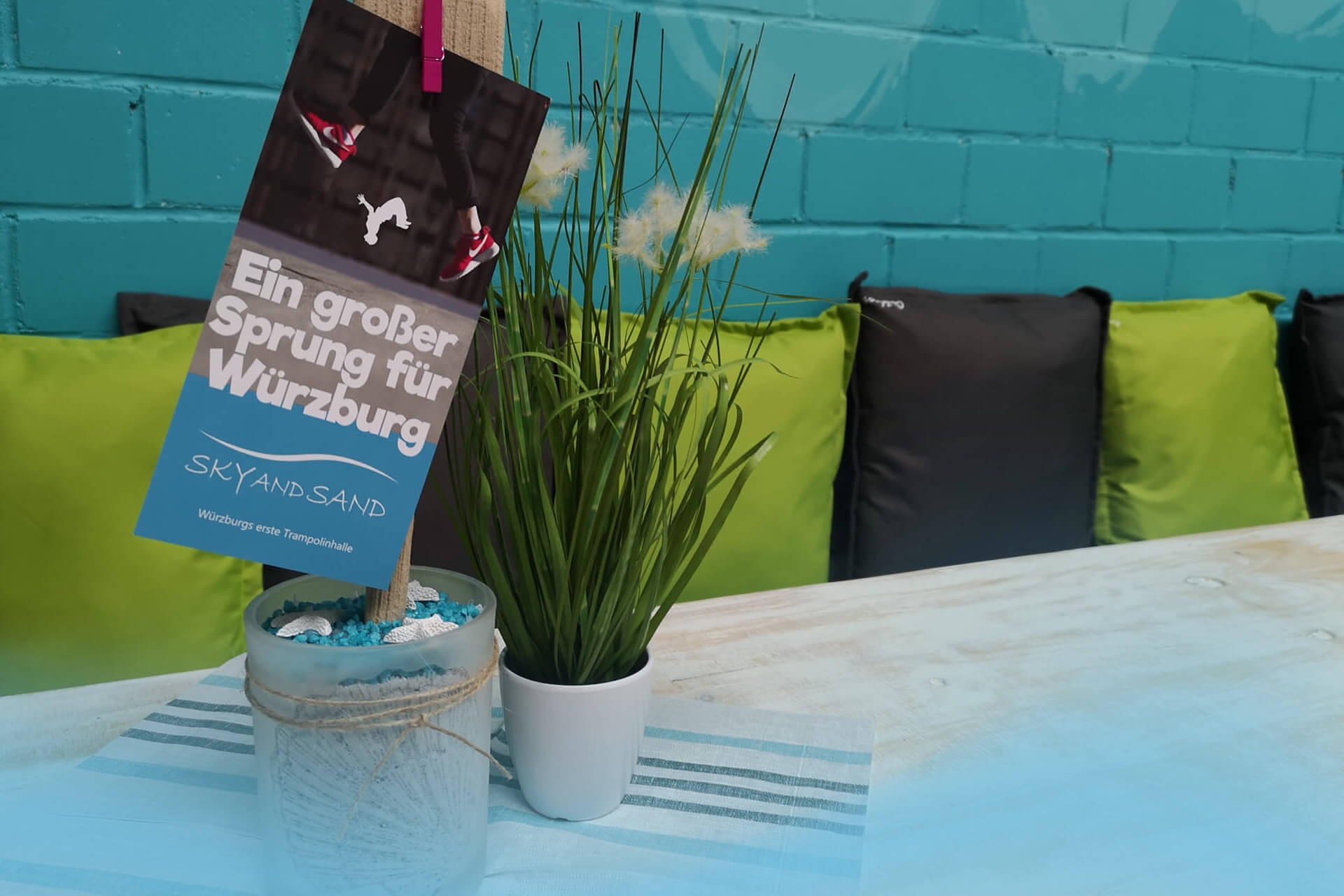 Detailaufnahme der Speisekarte auf einem Tisch im gemütlichen Aufenthaltsbereich des SkyandSand Trampolinparks Würzburg.